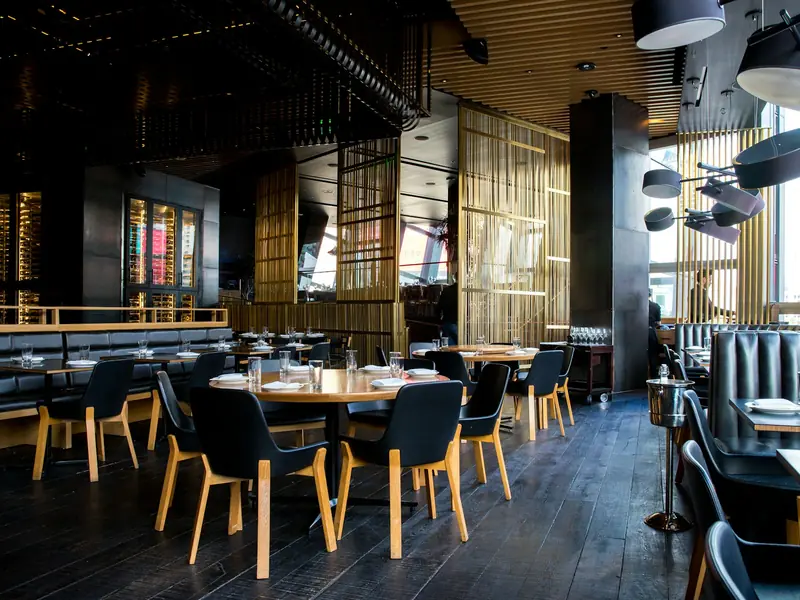 Comedor de un restaurante con mesas de madera y luz cálida